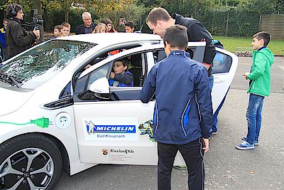 Maximilian Weiß durfte sich auch mal ans Steuer des stehenden E-Autos setzen, das die wissbegierigen Schülerinnen und Schüler ständig umlagerten.
