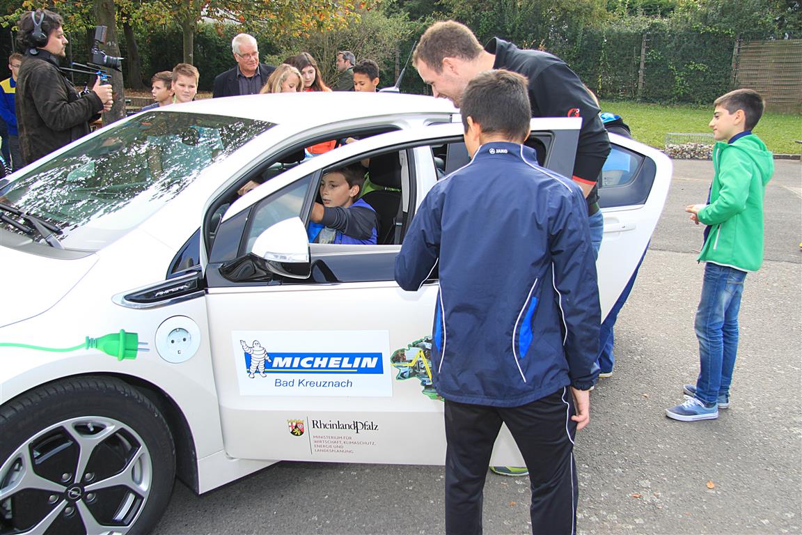 Maximilian Weiß durfte sich auch mal ans Steuer des stehenden E-Autos setzen, das die wissbegierigen Schülerinnen und Schüler ständig umlagerten.
